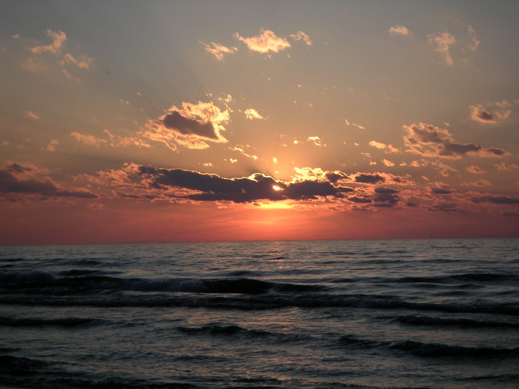 Sunset over Lake Michigan with rays breaking through clouds